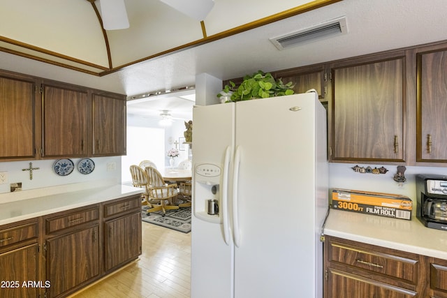 kitchen with ceiling fan, light wood-type flooring, and white fridge with ice dispenser