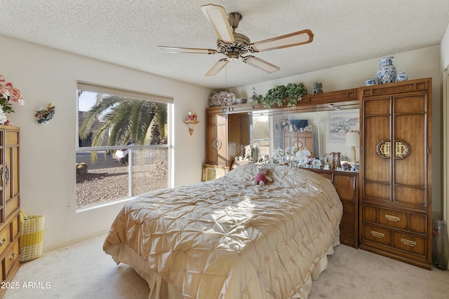 bedroom featuring ceiling fan, light colored carpet, and a textured ceiling