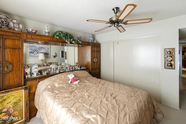 bedroom featuring ceiling fan, carpet, a textured ceiling, and a closet