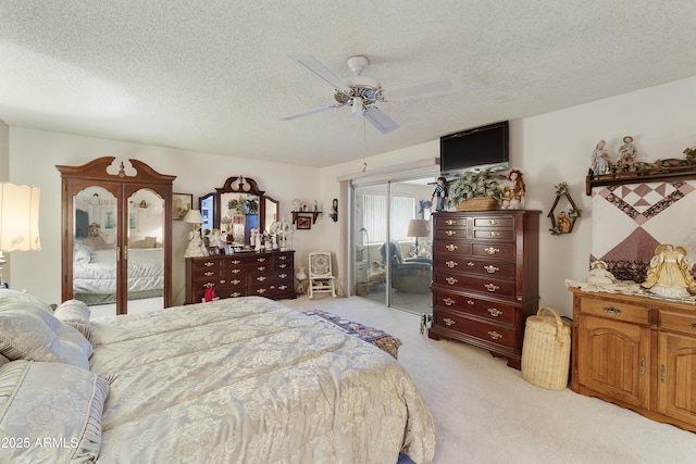 carpeted bedroom featuring ceiling fan, a closet, and a textured ceiling