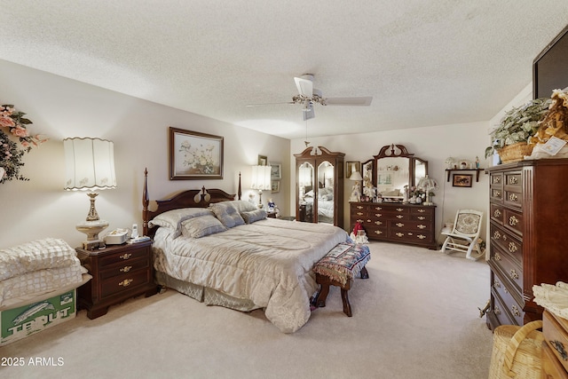 bedroom with ceiling fan, light colored carpet, and a textured ceiling