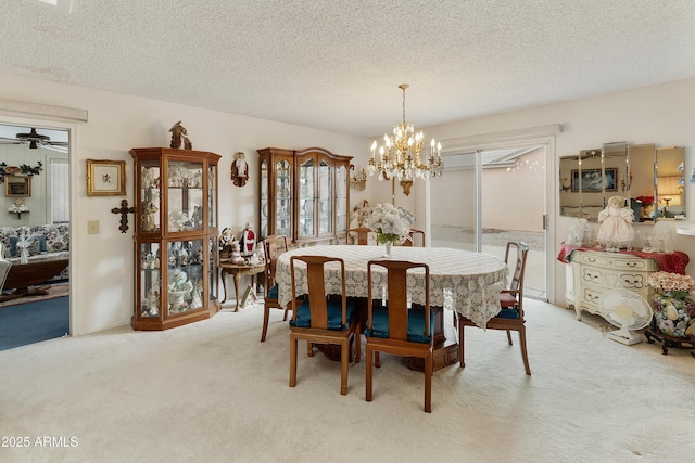 dining space with light colored carpet, ceiling fan with notable chandelier, and a textured ceiling