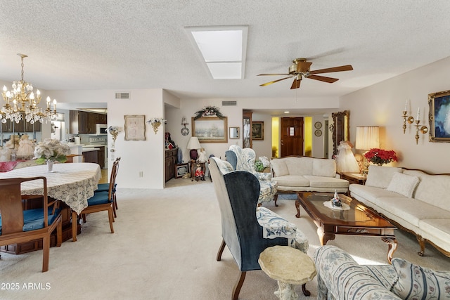 carpeted living room featuring ceiling fan with notable chandelier and a textured ceiling