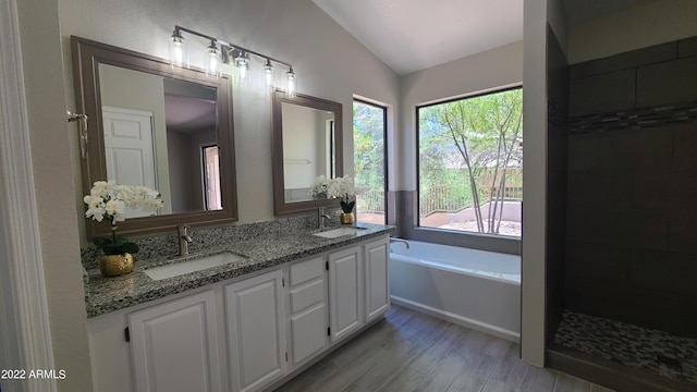 bathroom with vanity, hardwood / wood-style floors, vaulted ceiling, and separate shower and tub