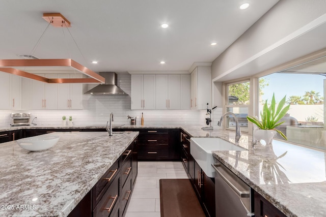 9921 E Doubletree Ranch Rd, Scottsdale, AZ 85258 - kitchen featuring wall chimney exhaust hood, stainless steel dishwasher, tasteful backsplash, white cabinets, and light tile patterned floors