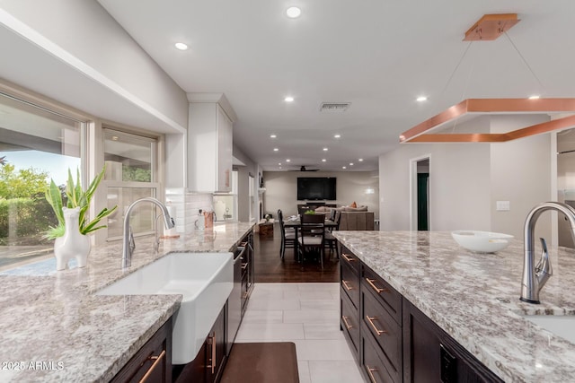 9921 E Doubletree Ranch Rd, Scottsdale, AZ 85258 - kitchen featuring light stone countertops, white cabinets, recessed lighting, backsplash, and light tile patterned floors