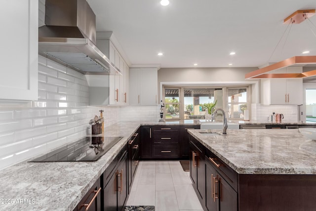 9921 E Doubletree Ranch Rd, Scottsdale, AZ 85258 - kitchen with wall chimney exhaust hood, black electric stovetop, tasteful backsplash, white cabinetry, and light stone countertops