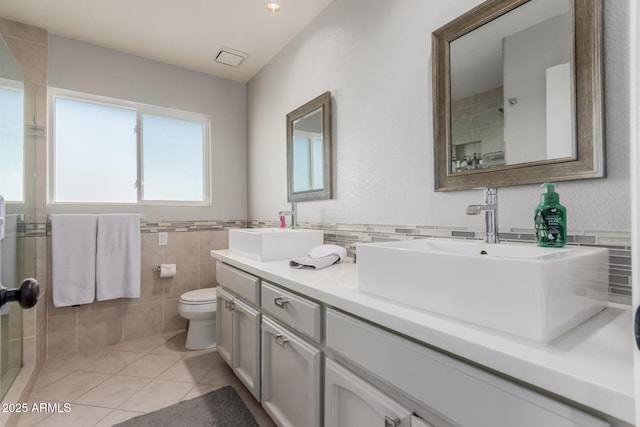 9921 E Doubletree Ranch Rd, Scottsdale, AZ 85258 - full bath featuring double vanity, tiled shower, tile walls, tile patterned floors, and wainscoting