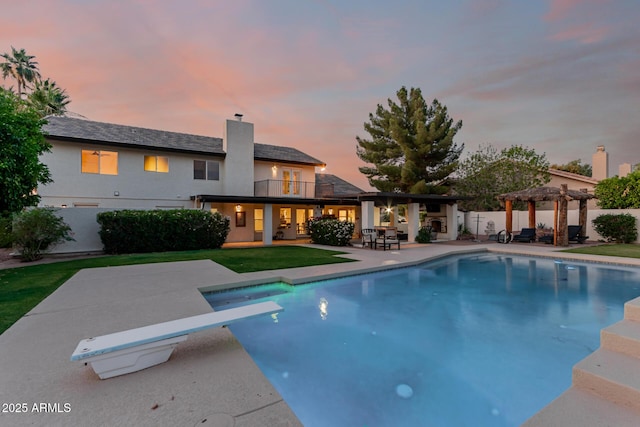 9921 E Doubletree Ranch Rd, Scottsdale, AZ 85258 - pool at dusk with a pergola, a diving board, and a patio