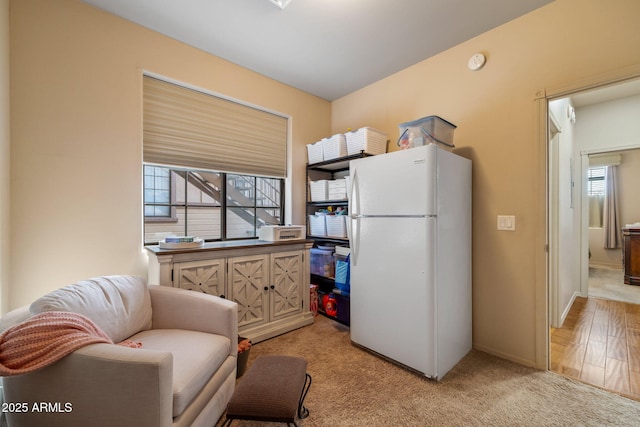 living area with a wealth of natural light and light colored carpet