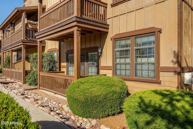 view of exterior entry featuring board and batten siding and a balcony