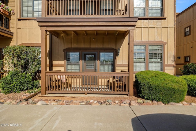 property entrance with board and batten siding and a balcony