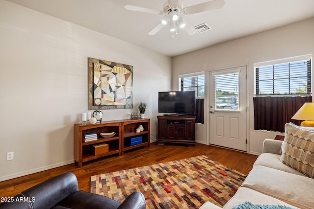 living room with a ceiling fan, baseboards, visible vents, and wood finished floors