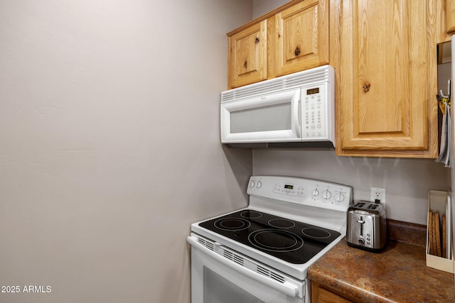 kitchen with dark countertops and white appliances
