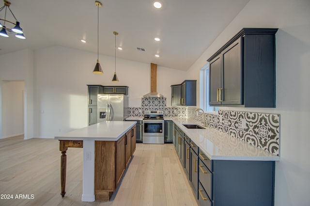 kitchen featuring pendant lighting, a center island, lofted ceiling, appliances with stainless steel finishes, and light hardwood / wood-style floors