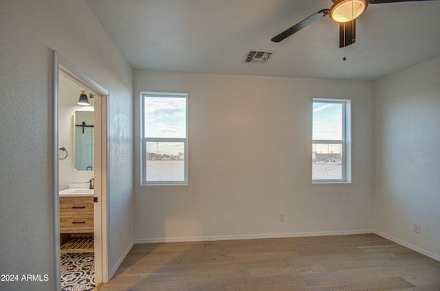 unfurnished bedroom with multiple windows, ceiling fan, and light hardwood / wood-style floors