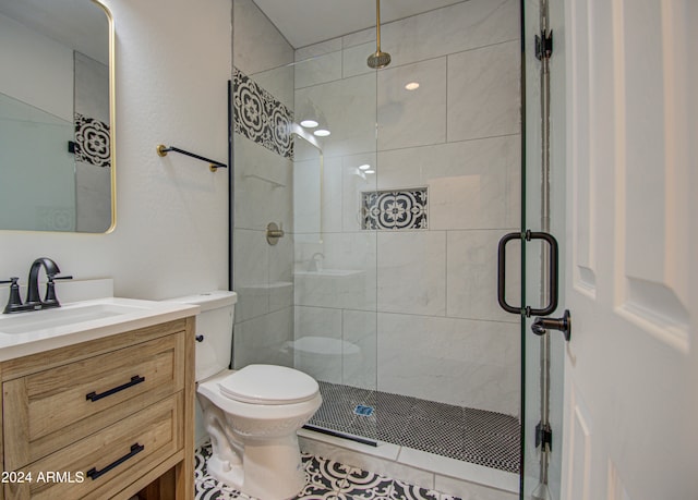 bathroom with tile patterned flooring, vanity, toilet, and a shower with door