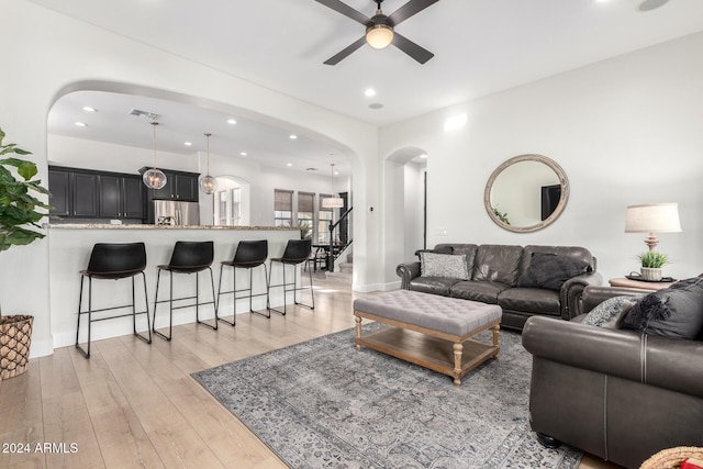 living room featuring light hardwood / wood-style floors and ceiling fan