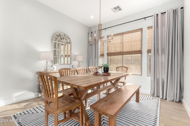 dining area featuring light wood-type flooring and a chandelier