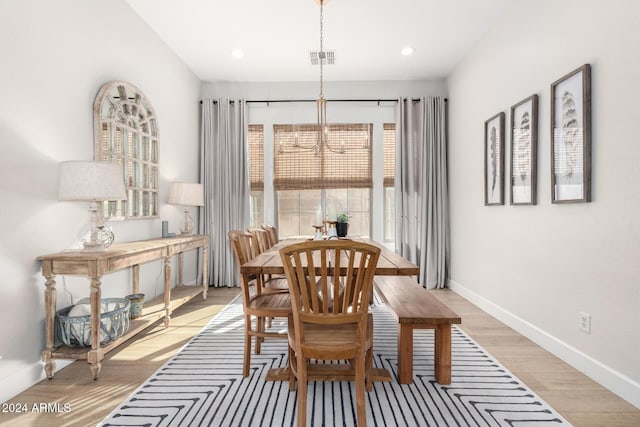 dining space featuring light hardwood / wood-style flooring and a notable chandelier