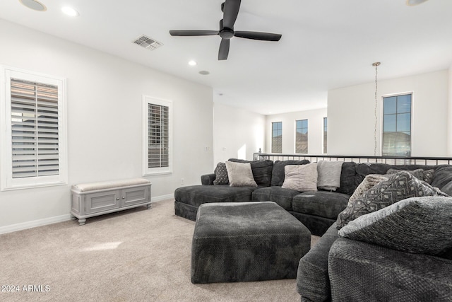 carpeted living room with ceiling fan