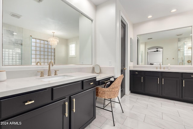 bathroom featuring ceiling fan with notable chandelier, vanity, and an enclosed shower