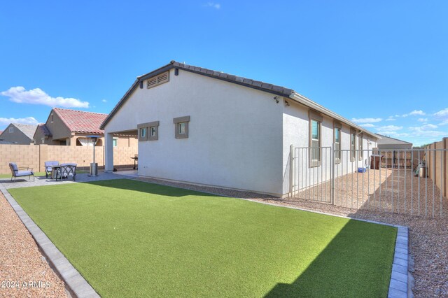 back of house featuring a yard and a patio area