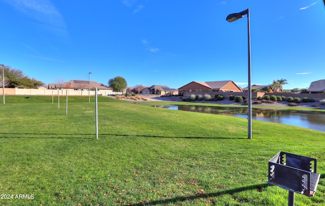 surrounding community featuring a lawn and a water view