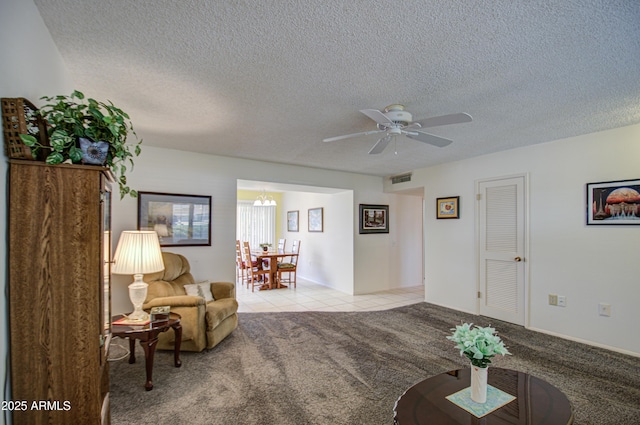 sitting room with visible vents, light carpet, a textured ceiling, and ceiling fan with notable chandelier