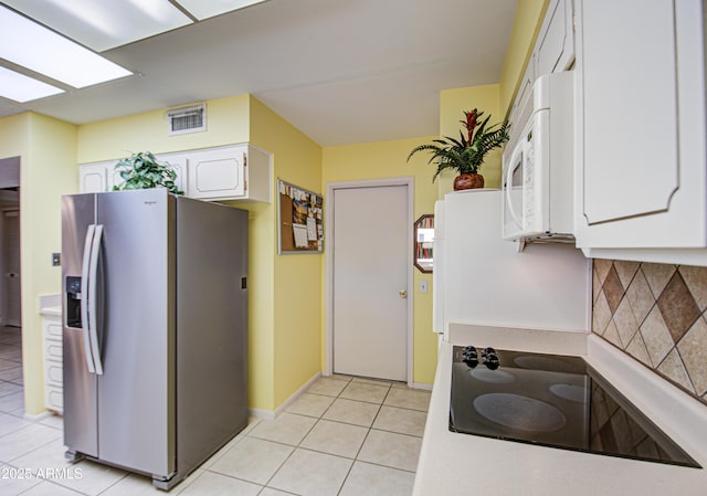 kitchen with tasteful backsplash, white cabinets, stainless steel fridge with ice dispenser, white microwave, and black electric stovetop