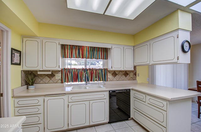 kitchen with dishwasher, a peninsula, light countertops, a sink, and light tile patterned flooring