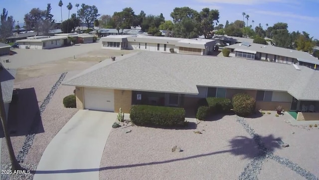 view of front facade with a garage, concrete driveway, and roof with shingles