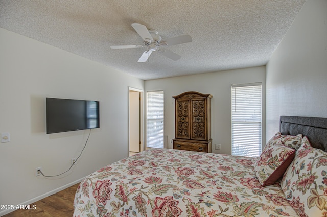 bedroom with ceiling fan, a textured ceiling, and wood finished floors