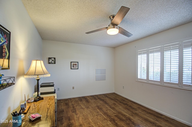 interior space with a textured ceiling, wood finished floors, a ceiling fan, and baseboards