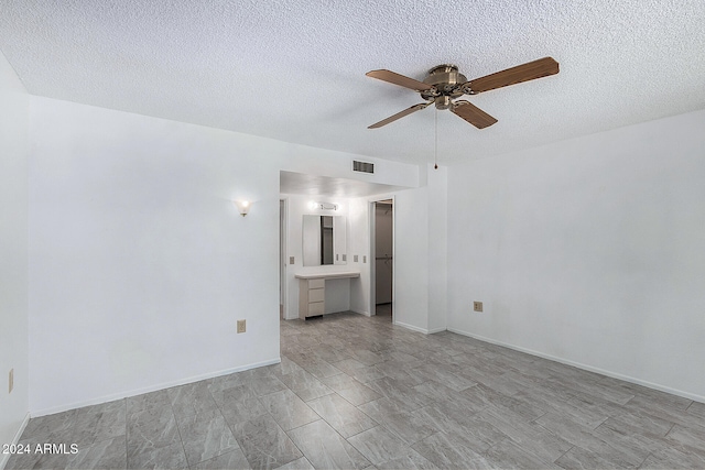 unfurnished room with a textured ceiling and ceiling fan