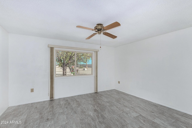 empty room featuring ceiling fan and a textured ceiling