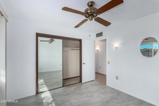 unfurnished bedroom featuring a textured ceiling, ceiling fan, and a closet