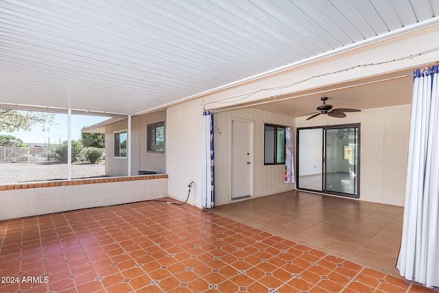 unfurnished sunroom featuring ceiling fan