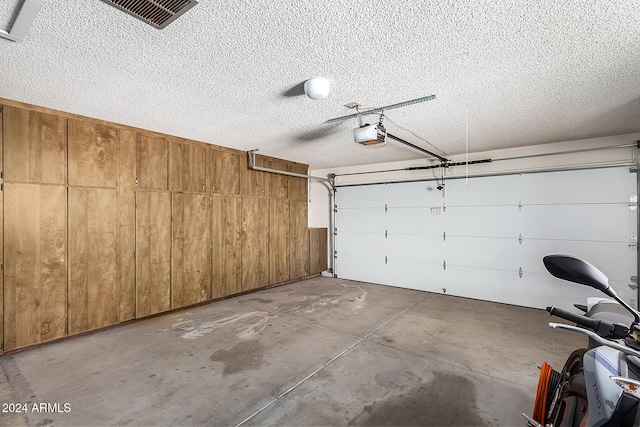 garage featuring wood walls and a garage door opener