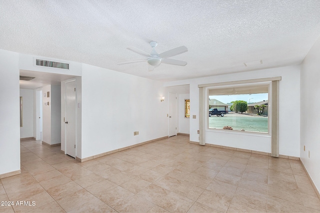 tiled spare room featuring ceiling fan and a textured ceiling