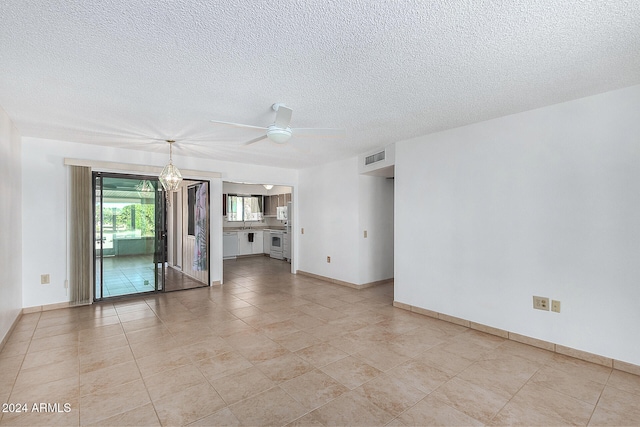 unfurnished living room featuring ceiling fan with notable chandelier, a textured ceiling, and light tile patterned floors