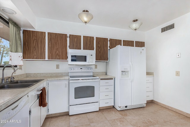 kitchen with sink, white appliances, and light tile patterned floors