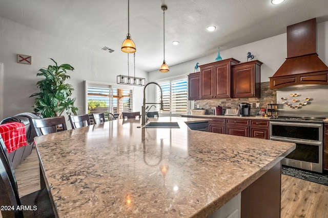 kitchen featuring electric range, custom exhaust hood, and a large island