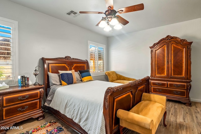 bedroom with light hardwood / wood-style flooring, multiple windows, and ceiling fan