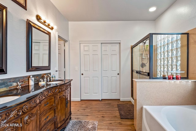 bathroom with hardwood / wood-style floors, vanity, and independent shower and bath