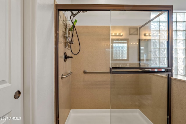 bathroom featuring an enclosed shower and a healthy amount of sunlight