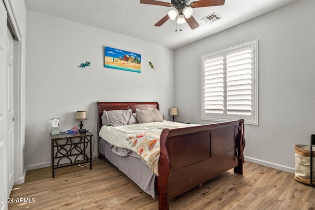 bedroom with light hardwood / wood-style flooring, a closet, and ceiling fan