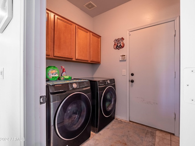 clothes washing area featuring cabinets, independent washer and dryer, and light tile patterned flooring