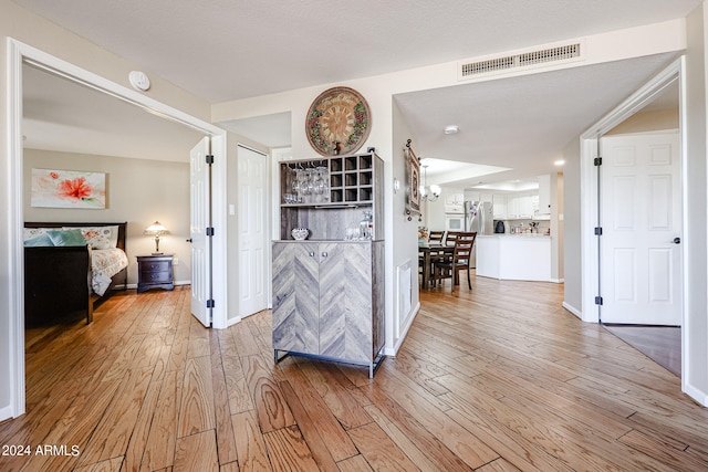 hallway with a chandelier and light hardwood / wood-style flooring