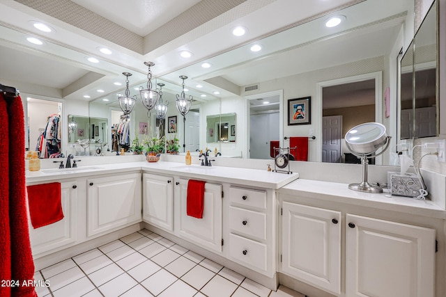 bathroom with vanity, tile patterned floors, and a tray ceiling